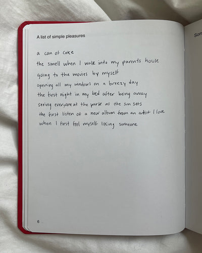 We're Not Really Strangers Journal. View of inside of journal page with prompt reading "A List of simple pleasures" with response in handwriting reading "a can of coke. the smell when I walk into my parents house. going to the movies by myself. opening my windows on a breezy day. the first night in my bed after being away. seeing everyone at the park as the sun sets. the first listen of a new album from an artists I love. when I first feel myself liking someone."